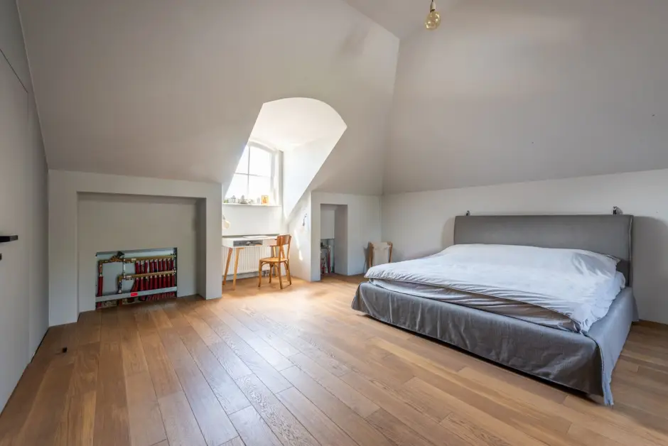 Chambre aménagée sous les combles avec plancher bois